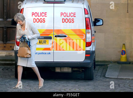 Theresa Maggio MP, Home Secretary, passeggiate passato un cane di polizia van nei giardini delle case del Parlamento, Westminster, London Foto Stock