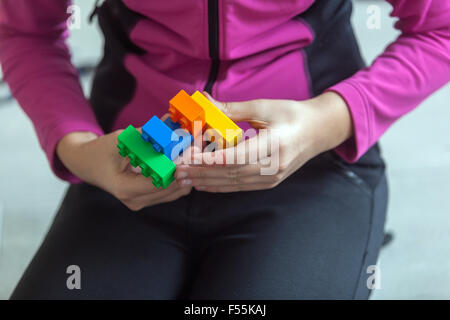 Cubi di plastica nelle mani di un bambino il gioco che sviluppa la creatività e la fantasia, mattoncini lego Foto Stock