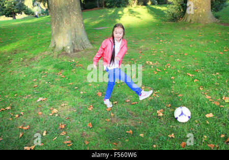 Carino bambina pagando nel parco con una sfera Foto Stock