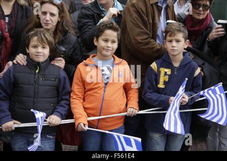 Atene, Grecia. Il 28 ottobre 2015. Tre ragazzi guardare il 'Oxi Day' sfilata in Atene, sventola una bandiera greca. Scuola gli studenti hanno marciato in Atene in 'Oxi Day' Parade, che commemora il 28. Ottobre del 1940, quando il greco dittatore Metaxas ha rifiutato di Mussolini richiesta per occupare la Grecia con un semplice "Oxi' (No). Era l'inizio dell'adesione della Grecia nella Seconda Guerra Mondiale. Credito: Michael Debets/Alamy Live News Foto Stock