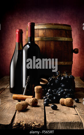 Bottiglie di vino, tappi, cavatappi e botte di legno sul tavolo Foto Stock