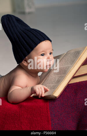 Neonato sdraiato sulla pila di libri Foto Stock