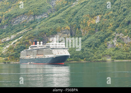 MS Queen Elizabeth II, ormeggiata nel Fiordo di Geiranger, Norvegia. Foto Stock