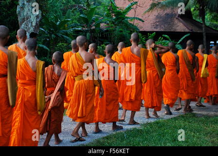 La linea dei monaci buddisti a piedi passato Angkor Wat complesso. Angkor Wat è stato per la prima volta un Indù, successivamente, un tempio buddista complesso. Foto Stock