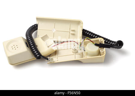 Rotto il vecchio ricevitore del telefono su sfondo bianco Foto Stock