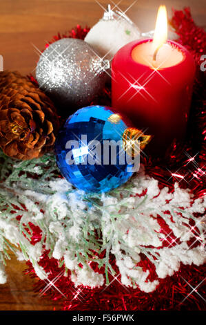 Decorazione di natale con candela che brucia e baubles splendente Foto Stock