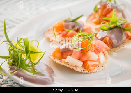 Ceviche di salmone serviti sul chip di taro e rabboccato con poi e cipolla verde guarnite Foto Stock