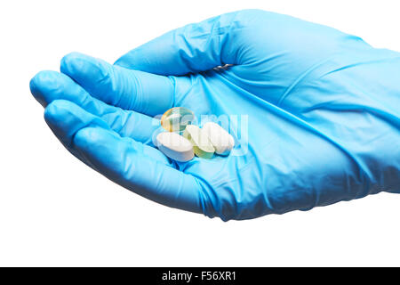 In prossimità dei due bianco e uno verde compresse morbide e capsula di gel con colore dorato dei supplementi di olio sulle donne medico la mano in bl Foto Stock