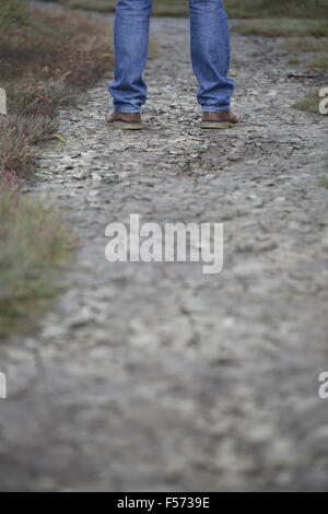 L uomo per le gambe in piedi sul suolo incrinato Foto Stock