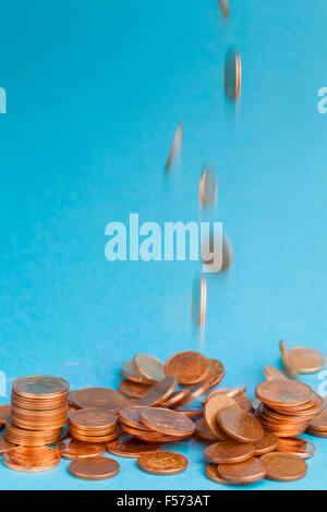 La caduta di cent di Euro monete in un centesimo e due centesimi a tagli su sfondo blu. Foto Stock
