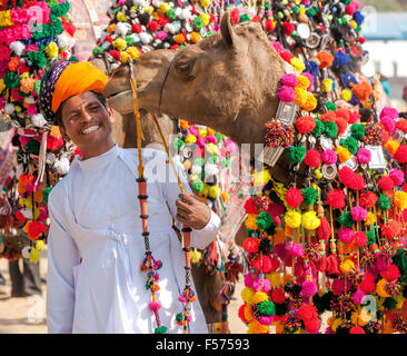 PUSHKAR, India - 22 novembre: il cammello e il suo proprietario non identificato assiste al tradizionale decorazione cammello concorrenza al camel mela Foto Stock