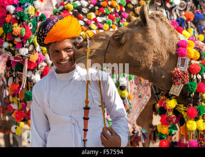 PUSHKAR, India - 22 novembre: il cammello e il suo proprietario non identificato assiste al tradizionale decorazione cammello concorrenza al camel mela Foto Stock