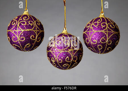 Tre sfere colorate e decorate per appendere l'albero di Natale per appendere su un bianco backgroun Foto Stock