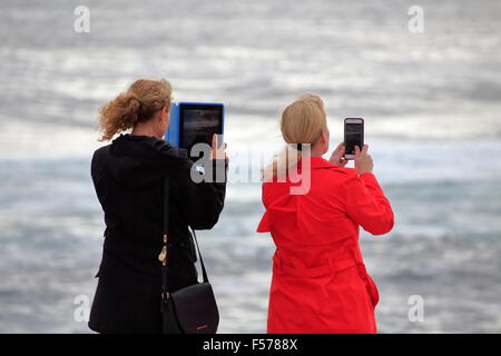 Due donne che assumono scenic foto fotografie o video utilizzando un grande tablet ipad e uno smart phone o iphone Foto Stock
