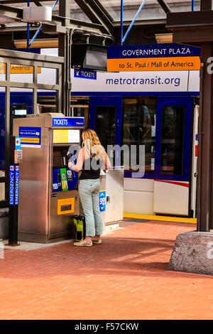 Giovane donna acquista il suo biglietto della metropolitana dalla macchina automatica in Downtown Minneapolis Città Foto Stock