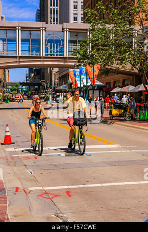 Due persone in bicicletta lungo Nicolette Mall in Downtown Minneapolis MN Foto Stock