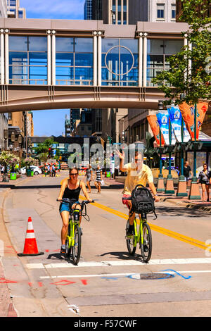 Due persone in bicicletta lungo Nicolette Mall in Downtown Minneapolis MN Foto Stock