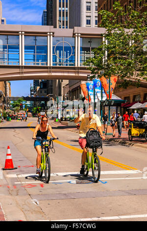 Due persone in bicicletta lungo Nicolette Mall in Downtown Minneapolis MN Foto Stock