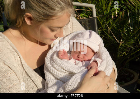 Madre con un giorno il vecchio baby ragazza seduta nella luce del sole. Baby jaundiced leggermente. Regno Unito. Foto Stock