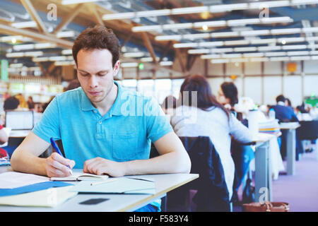 Studenti che lavorano nella moderna biblioteca pubblica di università Foto Stock