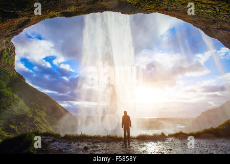 Incredibile cascata in Islanda, silhouette dell'uomo godendo di una vista fantastica della natura Foto Stock
