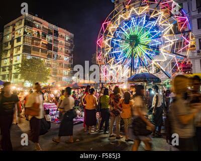 Yangon, Divisione di Yangon, Myanmar. 29 ott 2015. Un human powered ruota panoramica Ferris in una strada di carnevale nel centro di Yangon. L'elettricità è scarso in Myanmar, soprattutto nelle aree rurali e la maggior parte dei carnevali di viaggio uso human powered corse. Lavoratori salire in cima alla ruota panoramica Ferris e poi tirarlo intorno ad arrivare è la filatura. Essi fare lo stesso con il Merry Go Round, ma invece di salire alla cima essi tirarlo intorno a. Credito: ZUMA Press, Inc./Alamy Live News Foto Stock