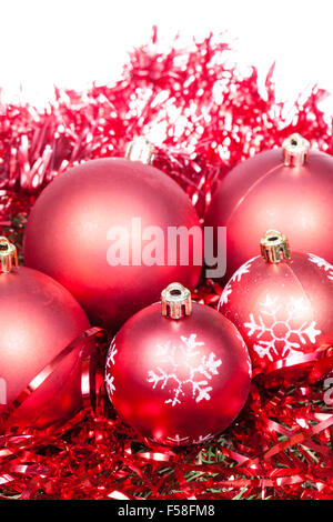 Cinque rosso baubles di Natale e tinsel isolati su sfondo bianco Foto Stock