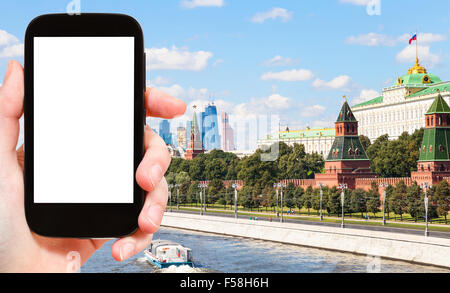 Concetto di viaggio - mano trattiene smartphone con tagliare fuori schermo e città di Mosca sullo sfondo Foto Stock