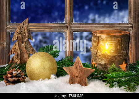 Natale, Avvento o inverno disposizione stagionale su un davanzale, decorata con neve, con accogliente a lume di candela, ornamenti e fi Foto Stock