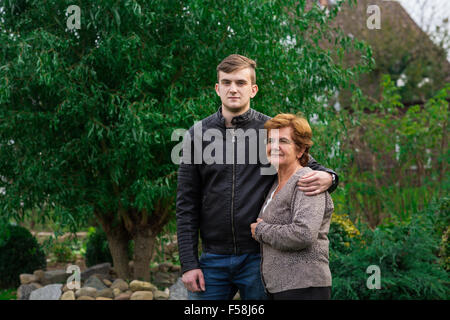 Il giovane e la sua madre di abbracciare per una foto all'aperto. medium shot. Foto Stock
