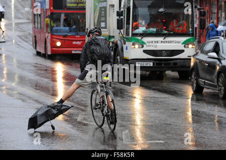 Londra, UK, 30 ottobre 2015, ciclista evita perso ombrello in strada a piovoso venerdì mattina a Clapham Junction come pendolari in testa al lavoro. Credito: JOHNNY ARMSTEAD/Alamy Live News Foto Stock