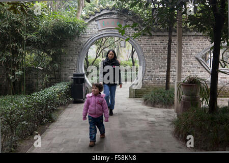 Una madre segue la figlia in un vecchio giardino di una vecchia chiamata Gucheng in Pixian alla periferia di Chengdu in Cina. Foto Stock