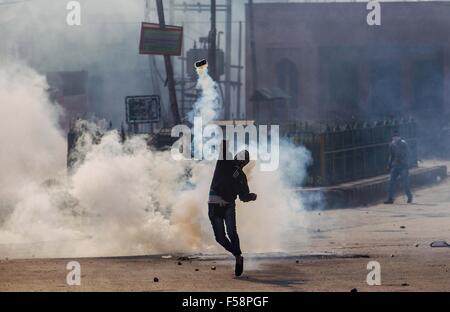 Srinagar, Indiano-controllato del Kashmir. 30 ott 2015. Un musulmano del Kashmir protester getta un esploso di una lacerazione della shell di fumo torna alla polizia indiana e di paramilitari troopers (invisibile) durante una manifestazione di protesta a Srinagar, capitale estiva di Indiano-Kashmir controllata, Ottobre 30, 2015. Musulmani del Kashmir manifestanti si scontrano con la polizia indiana e di paramilitari troopers dopo le preghiere del venerdì oltre l uccisione di Abu Qasim, un alto comandante militante voce Lashkar-e-Toiba (LET) in irrequieta indiano-Kashmir controllata. Credito: Javed Dar/Xinhua/Alamy Live News Foto Stock