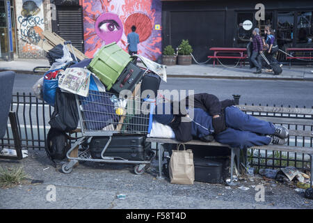 Senzatetto uomo dorme accanto ai suoi averi sul Lower East Side di New York City. Foto Stock