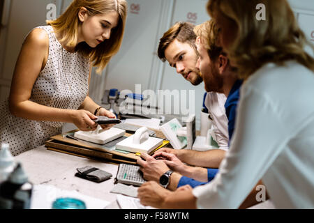 Collaboratori creativi mettendo la loro immaginazione alla prova nel disegnare vestiti Foto Stock