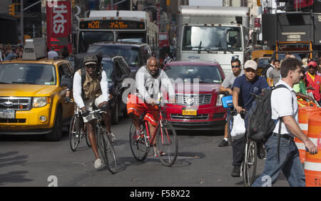 Moto coraggiosi messaggeri correre in bici in mezzo alla costante din del traffico sulla settima avenue in Times Square NYC. Foto Stock