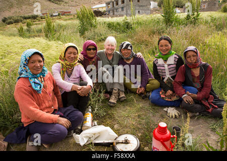 India, Himachal Pradesh, Spiti Valley, Losar village, un gruppo di donne locali tenendo pausa dal lavoro nei campi con il turista occidentale Foto Stock
