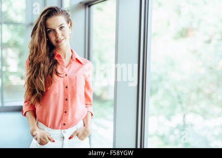 Ritratto di una bella imprenditrice con le mani nelle tasche Foto Stock
