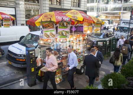 Cucina di strada fornitore ha un buon posto sulla 40th Street lungo il Bryant Park di New York City. Foto Stock