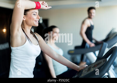 Giovane e bella donna di formazione da parte di una bicicletta in una palestra e sudorazione Foto Stock