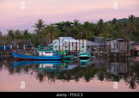 Barche da pesca nei pressi di case di pescatori nella zona rurale dell'isola di Phu Quoc, Vietnam del Sud. Foto Stock