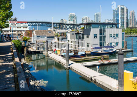 Sea Village a Granville Island, con diverse case galleggianti e piccole barche ormeggiate, Vancouver, BC, Canada. Burrard Bridge dietro. Foto Stock