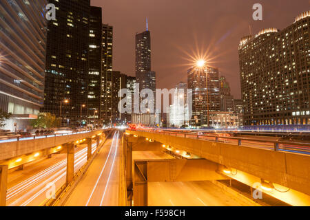 Edifici di Chicago, overhead torreggianti, overground ferrovia, strada urbana e flussi di luci con riflessi di luce dalle luci della strada, il Foto Stock