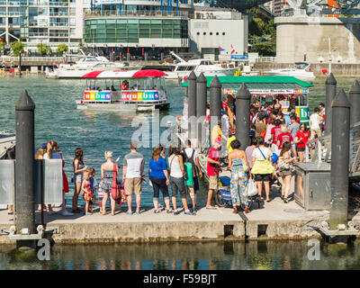 I passeggeri in attesa di aquabus False Creek traghetti a Granville Island dock sul Canada Il giorno 1 luglio 2015. Foto Stock