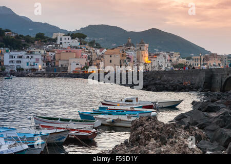 Ischia, Italia - 15 agosto 2015: Cityscape con barche di Ischia Porto al tramonto mediterraneo sulla costa del mare Foto Stock