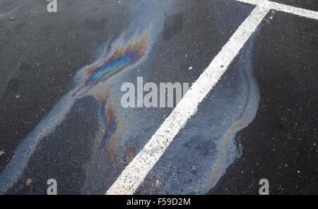 Fuoriuscita di olio su asfalto scuro, parcheggio con linee divisorie Foto Stock