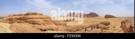 Gruppo di persone su una montagna nel deserto, paesaggio surreale, veicoli off road in background Foto Stock