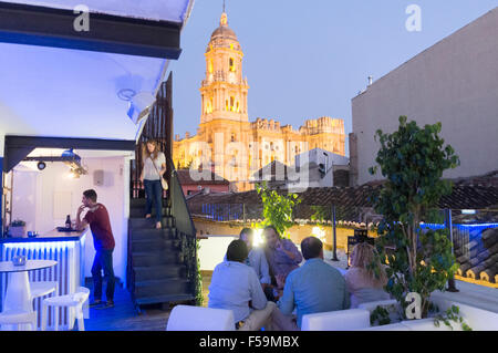 Persone a Chinitas Ostello urbano rooftop lounge bar con duomo illuminato in background. Malaga, Andalusia, Spagna. Foto Stock