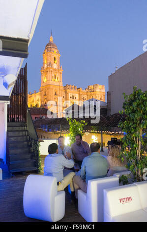 Persone a Chinitas Ostello urbano rooftop lounge bar con duomo illuminato in background. Malaga, Andalusia, Spagna. Foto Stock