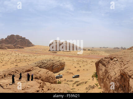 Gruppo di persone in un tour nel deserto paesaggio - monti rossi, blu cielo Foto Stock